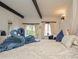 A bedroom with towels arranged in swan shapes at Poldark Cottage East Taphouse