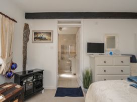 A bedroom with a bed and a bathroom entrance at Poldark Cottage in East Taphouse
