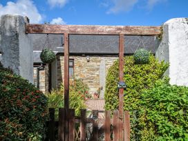 A garden gate leading to a stone house at Poldark Cottage in East Taphouse