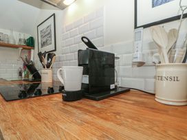 A kitchen with a coffee maker and utensils on a wooden countertop at The Hayloft Northop near Chester