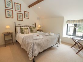 A bedroom with a bed and bedside table at The Hayloft in Northop near Chester