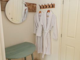 A hallway with bathrobes hanging on hooks and a table at The Hayloft near Chester