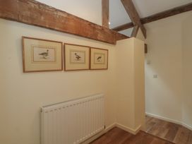 A hallway with framed artwork and a radiator at The Hayloft in Northop near Chester
