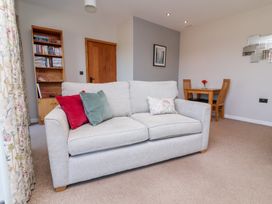 A living room with a sofa and dining table at Pound Cottage in Huntshaw near Great Torrington