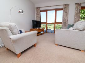A living room with a sofa and television at Pound Cottage in Huntshaw near Great Torrington