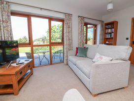 A living room with a sofa and television at Pound Cottage in Huntshaw near Great Torrington
