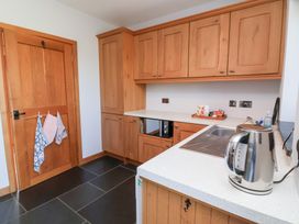 A kitchen with wooden cabinets and sink at Pound Cottage in Huntshaw near Great Torrington