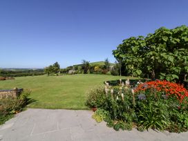 A garden with grass, trees, and flowers at Pound Cottage in Huntshaw near Great Torrington