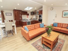 A living room with sofa and dining area at Beech Hill Lodge (Beech Hill 9) at Fallbarrow Park, Bowness-on-Windermere