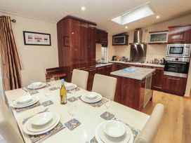 A kitchen with a dining table set for a meal at Beech Hill Lodge (Beech Hill 9) at Fallbarrow Park