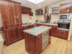 A kitchen with cabinets, an island, and cooking appliances at Beech Hill Lodge (Beech Hill 9) at Fallbarrow Park