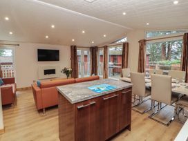 A living room with a sofa and dining area at Beech Hill Lodge (Beech Hill 9) at Fallbarrow Park, Bowness-on-Windermere