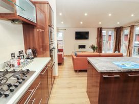 A kitchen with a gas stove and a sofa at Beech Hill Lodge (Beech Hill 9) at Fallbarrow Park, Bowness-on-Windermere