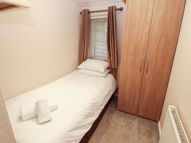 A single bedroom with a bed and wardrobe at Beech Hill Lodge (Beech Hill 9) at Fallbarrow Park, Bowness-on-Windermere