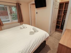 A bedroom with a bed and television at Beech Hill Lodge (Beech Hill 9) at Fallbarrow Park, Bowness-on-Windermere