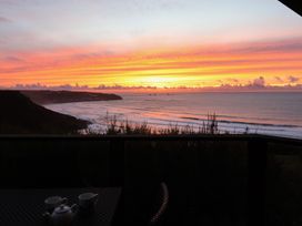 A sunset view over the ocean with a teapot and cups at Cragford in Sennen Cove