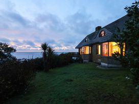 A house with illuminated windows near the sea at Cragford in Sennen Cove