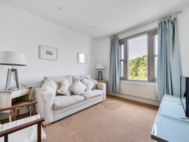 A living room with a sofa and lamp at Cragford in Sennen Cove