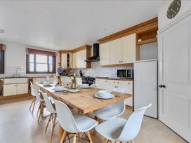 A kitchen with a dining table and chairs at Cragford Sennen Cove