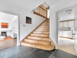 A hallway with a staircase and kitchen view at Cragford in Sennen Cove