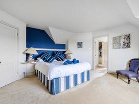 A bedroom with a bed and chair at Cragford Sennen Cove