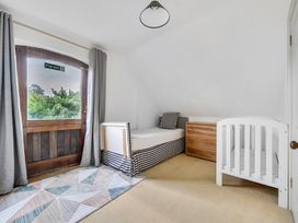 A bedroom with a bed, crib and chest of drawers at Cragford in Sennen Cove