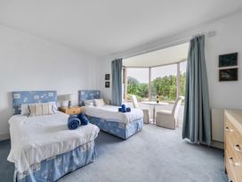 A bedroom with two beds and table at Cragford in Sennen Cove