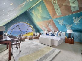 A bedroom with a large window and sea view at Cragford in Sennen Cove
