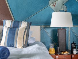 A bedroom with a bed, lamp, and breakfast items at Cragford in Sennen Cove