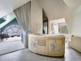 A bathroom with a bathtub and window at Cragford in Sennen Cove