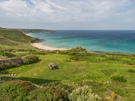 A beach and ocean view with a picnic table at Cragford in Sennen Cove