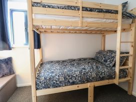 A bunk bed with floral bedding in a bedroom at The Long Barn near Morton on the Hill