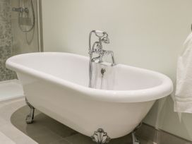 A white clawfoot bathtub with chrome fixtures and a walk-in shower in a bathroom at Lavender Cottage in Market Weighton