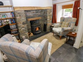 A living room with a fireplace and armchairs at Milk Wood Cottage in Laugharne