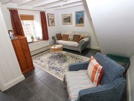 A living room with a sofa and armchair at Milk Wood Cottage Laugharne