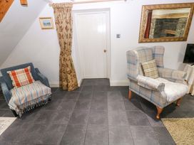 A living room with an armchair and sofa at Milk Wood Cottage in Laugharne