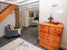 A living room with a chest of drawers and a chair at Milk Wood Cottage in Laugharne