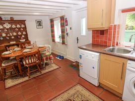 A kitchen with a dining area and a dishwasher at Milk Wood Cottage in Laugharne