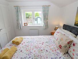 A bedroom with a bed and a window at Milk Wood Cottage in Laugharne