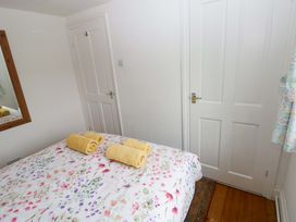 A bedroom with a bed and towels at Milk Wood Cottage in Laugharne