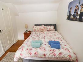 A bedroom with a bed and bedside table at Milk Wood Cottage in Laugharne
