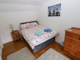 A bedroom with a bed and bedside table at Milk Wood Cottage in Laugharne