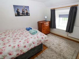A bedroom with a bed and towels on top at Milk Wood Cottage in Laugharne