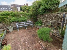 A garden with a bench and plants at Milk Wood Cottage in Laugharne