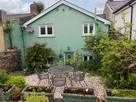 A garden area with a table and chairs at Milk Wood Cottage in Laugharne