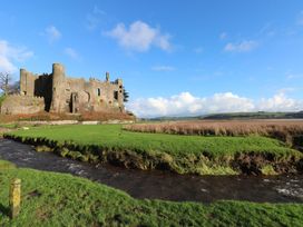A castle near a stream at Milk Wood Cottage in Laugharne