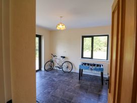 A room with a bicycle and a foosball table with windows showing outside at Curraha in Lauragh County Kerry