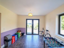 A room with recycling bins a bicycle and a foosball table with glass doors and a window at Curraha in Lauragh County Kerry