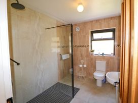A bathroom with a walk-in shower toilet sink and window at Curraha in Lauragh County Kerry