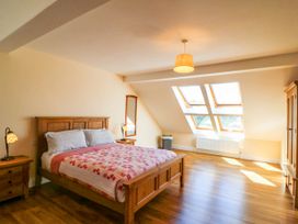 A bedroom with a wooden bed and nightstands under skylight windows at Curraha in Lauragh County Kerry